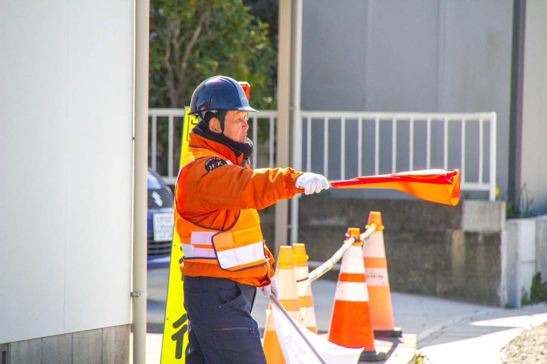 車両に対して止まれのサインを出している警備員