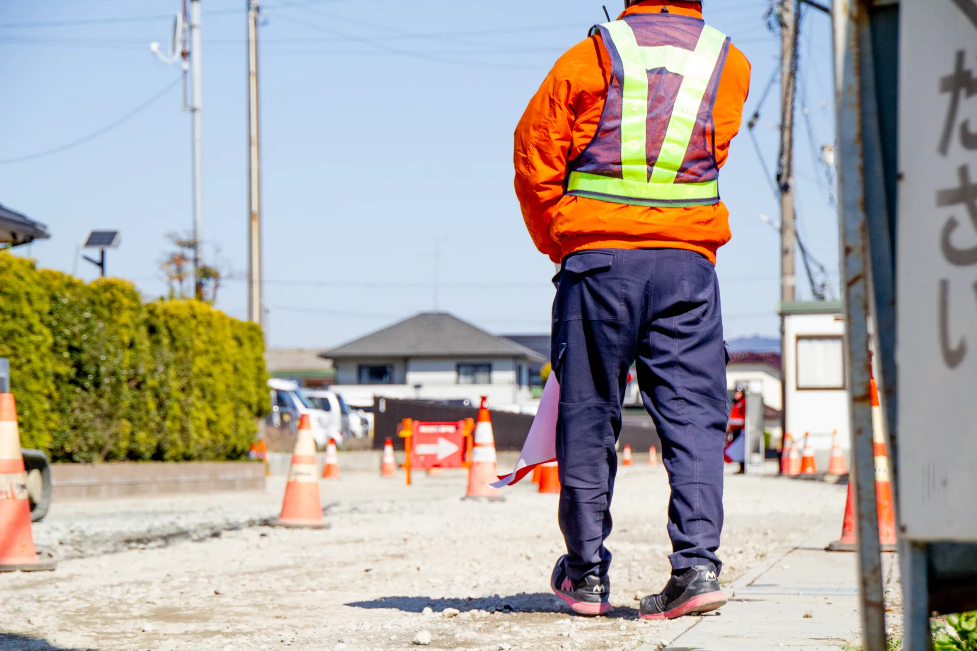 遠くを見ている警備員の後ろ姿